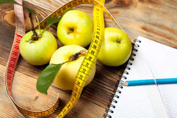 Green apples, diet and centimeter on a rustic wooden background