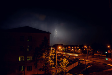 Fototapeta na wymiar Thunderstorm with lightning over the houses at residential area at Moscow suburb
