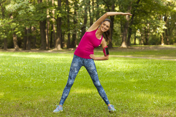 Fototapeta premium Young fitness woman is warming out outside.