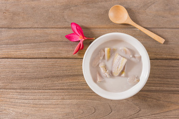 Thai dessert banana in coconut milk on old wooden floor
