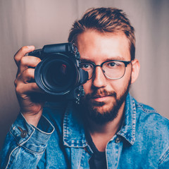 Male photographer with camera in arm