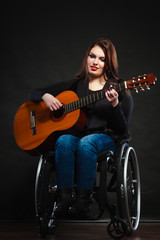 Handicapped girl holding guitar.