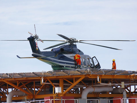 Helicopter or chopper land at oil and gas platform area for get and sent passenger from onshore hangar to offshore platform. Ground staff put in jet-A1 fuels in helicopter. 