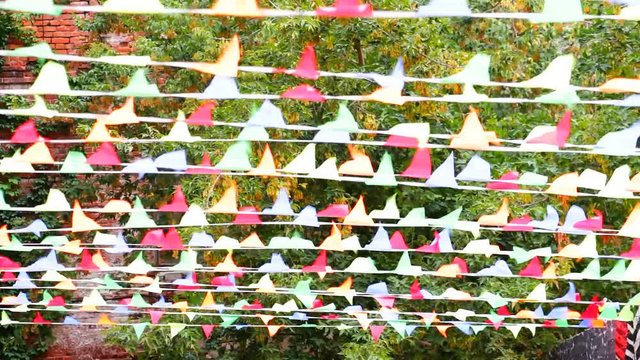 Multicolored festive small flags of a triangular shape swaying in the wind