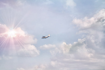 a small passenger plane flying in the sky with clouds