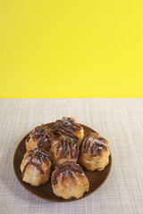 Chocolate cream puff on wooden background.