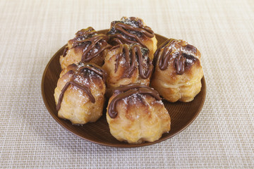 Chocolate cream puff on wooden background.