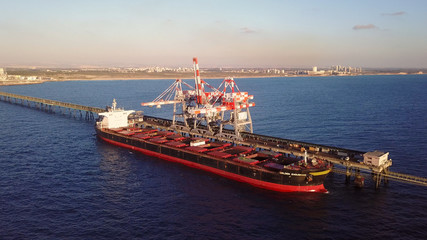 Large bulk carrier ship docking - Unloading coal ship by cranes on the power station dock