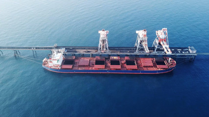 Large bulk carrier ship docking - Unloading coal ship by cranes on the power station dock