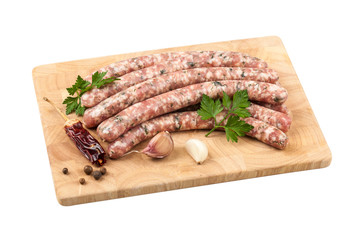 Raw sausages on board, isolated on white