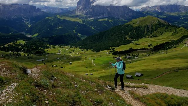 Hiker climbs along the path in beautiful highlands of Dolomites