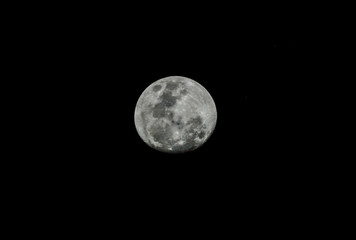 Naklejka na ściany i meble Close up of full moon over black sky. Black and white.