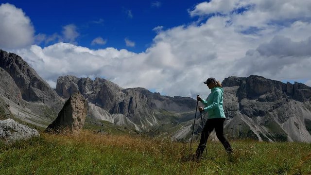 Woman makes a hike in beautiful highlands of Dolomites in Italy