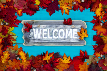 Rustic welcome sign with colorful fall leaves border © laurha