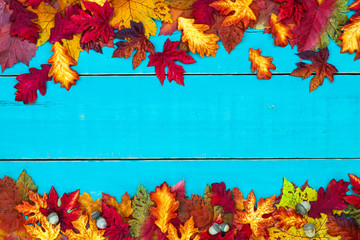 Blank teal blue wood sign with colorful autumn leaves border