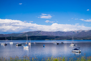 Naklejka premium White yachts, blue sky and blue clear water Grand Lake. Fishing in the rocky mountains