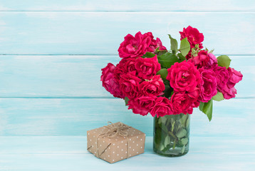 Roses bouquet and gifts on wooden background