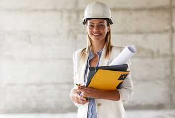 Portrait of female architect at the construction site. - obrazy, fototapety, plakaty