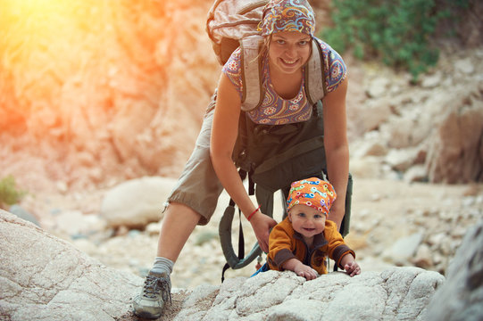 Mom and his little son are climbing in the canyon