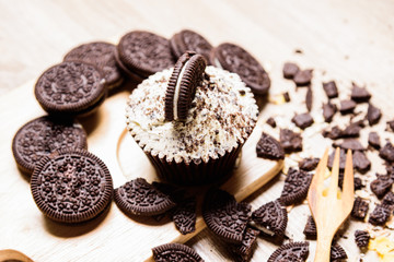 Homemade Chocolate cupcakes and cookies are in wooden plates.