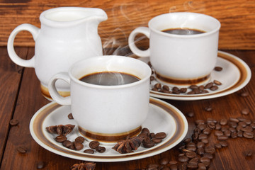 cup of hot black coffee and jug of milk