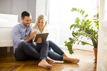 Young couple sitting on the floor with tablet