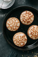 The process of cooking pancakes on a black background and set of ingredients