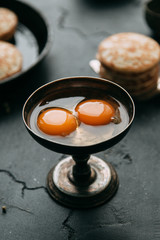The process of cooking pancakes on a black background and set of ingredients