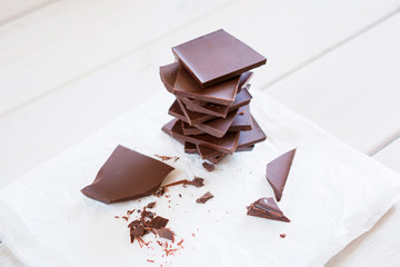 Pieces of chocolate stacked on a white napkin