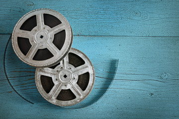 Old film strip on wooden blue background. Top view.