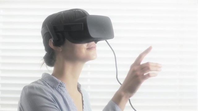 Beautiful businesswoman interacting in virtual reality. 4K UHD footage rendered at 16-bit color depth. (All logos and identifying marks removed in post.)