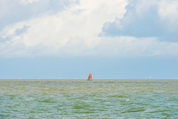 Boat sailing in a stormy lake in sunlight in summer