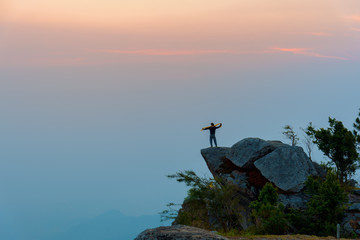 Backpacker standing at rock cliff at Khao Luang, Sukhothai, Thailand. Mountain trekking and...