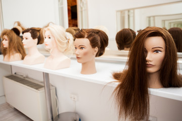 Different mannequin with different hairstyles on a stand. Dummy artificial model