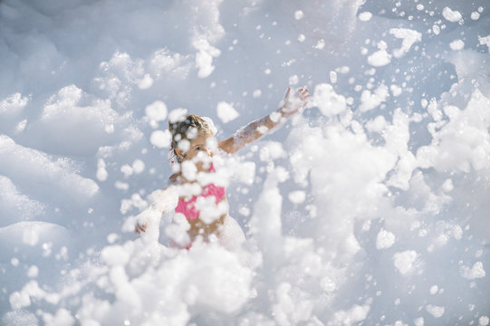 Girl playing in foam outside
