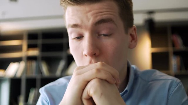young working man is very tired and overworked because of stressful and pressure business tasks siting at the table with laptop computer in the office space