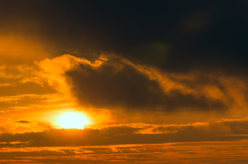 A fiery orange sunset, a great sun and a cloud of fire.