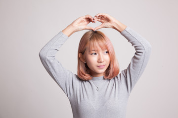 Young Asian woman gesturing  heart hand sign.