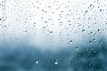 Naklejka na ściany i meble Raindrops on the glass, blurry landscape on background