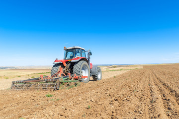 Obraz premium agricultural tractor in the foreground with blue sky background.