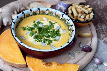 Pumpkin cream soup with crackers and ginger, parsley and  seeds