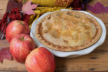 Whole Apple Pie in a Baking Dish with Red Apples