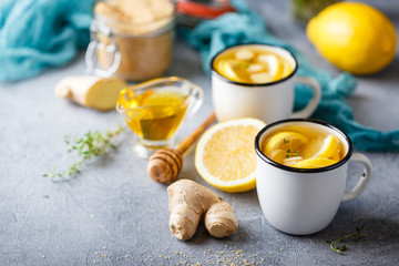 Obraz na płótnie Canvas Cups of ginger tea with honey and lemon
