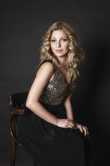 Obraz na płótnie Canvas beautiful blonde girl sitting in sparkling dress