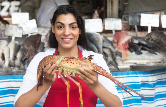 Beautiful woman selling seafood on a latin fish market
