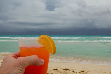 tomando tequila sunrise en la playa 