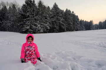 Fototapeta na wymiar Mädchen bei Dämmerung im Schnee vor einem Wald 
