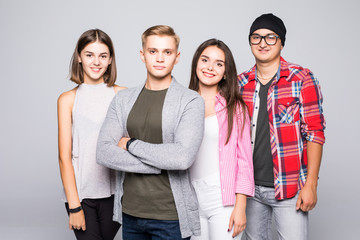 Fototapeta premium Happy smiling young group of friends standing together isolated on white