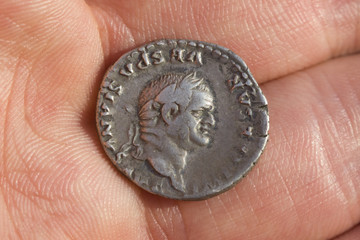 Hand holding Roman denarius (Roman silver coin)