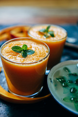 From above view of two glass orange smoothie with leaves of fresh mint